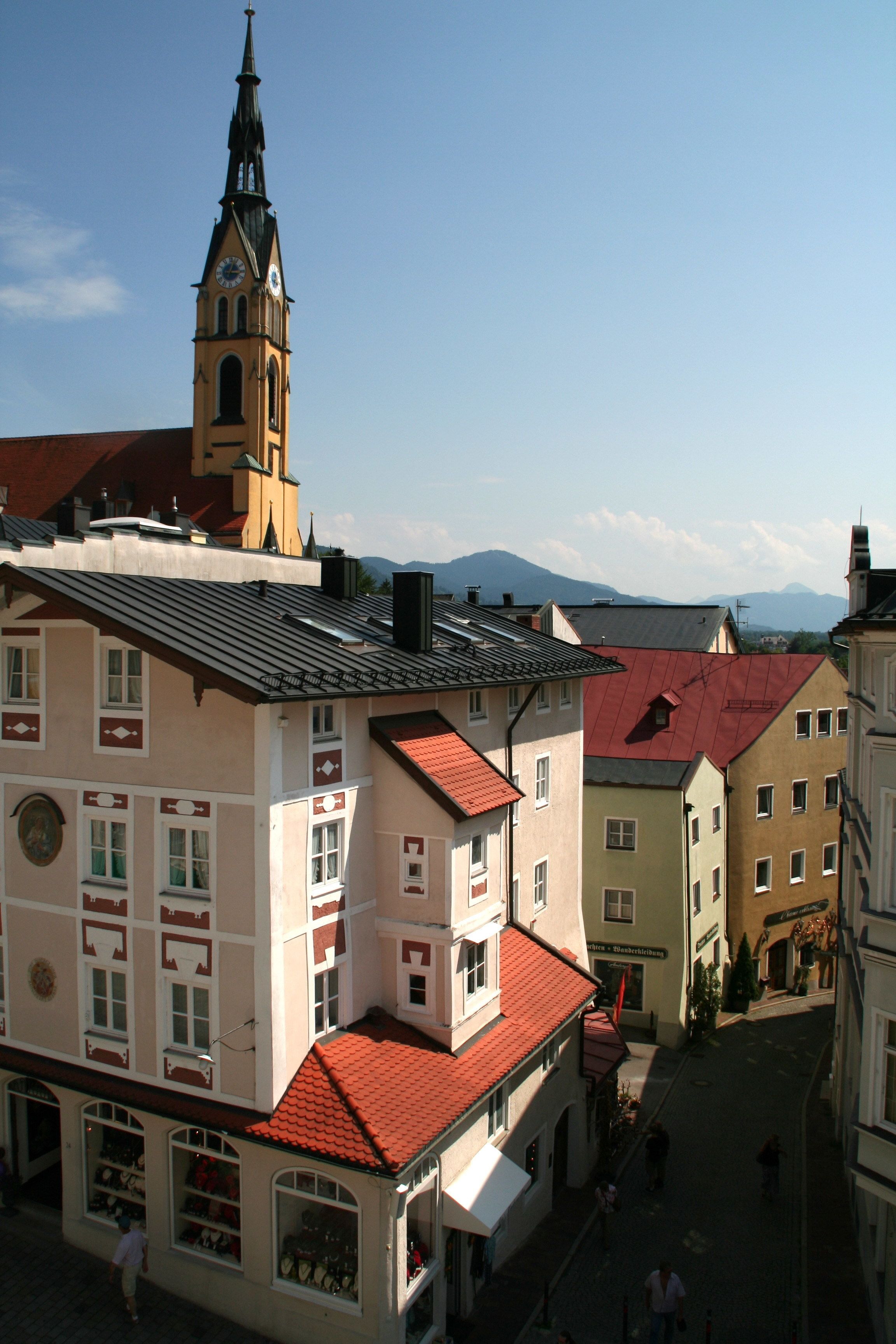 A historic building with a clock tower, red-tiled roofs, and a cobblestone street.