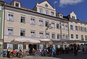 A building with multiple windows and a sign that reads "Posthotel und das Hotel Kolberbrunn".