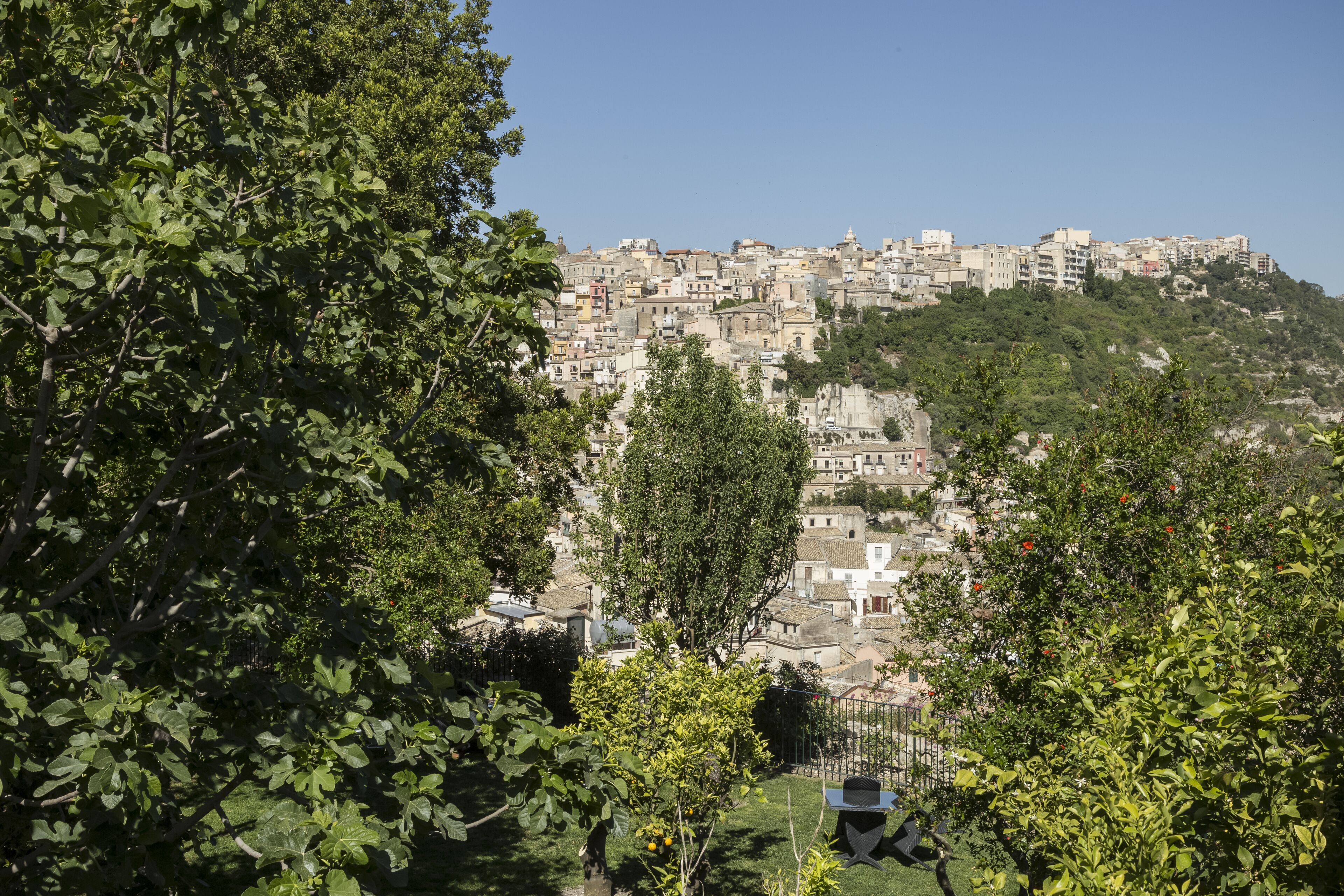 A hillside town with dense buildings and lush greenery.