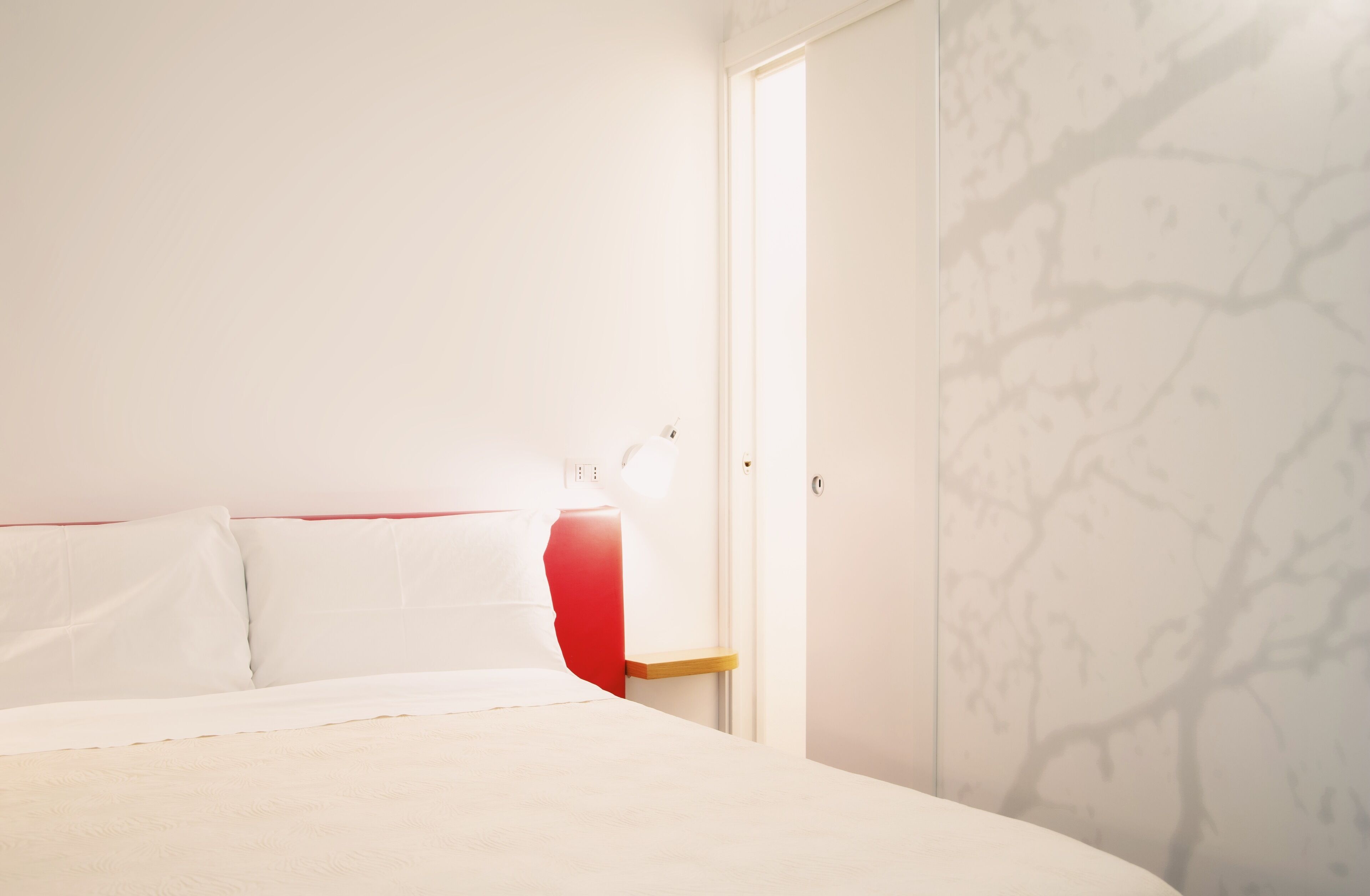 Ein Schlafzimmer mit Bett, Nachttisch und Tür.