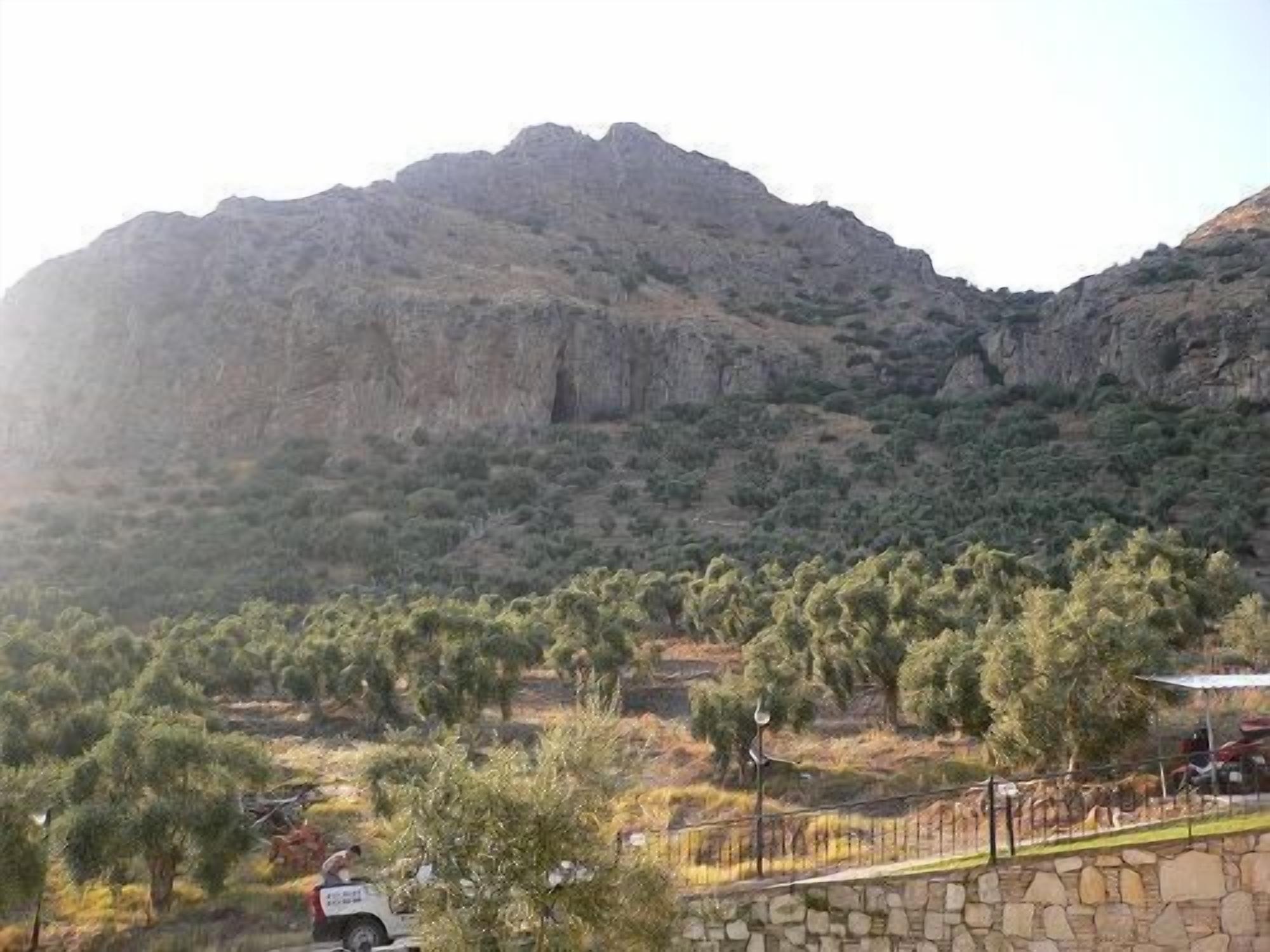 A mountainous landscape with a stone wall and a vehicle.