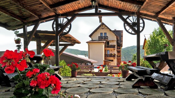 A wooden gazebo with a view of a mountain house. - Pensiunea Casa Humor (Gura Humorului)