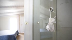 A room with a bed, a door, and a hanging towel.
