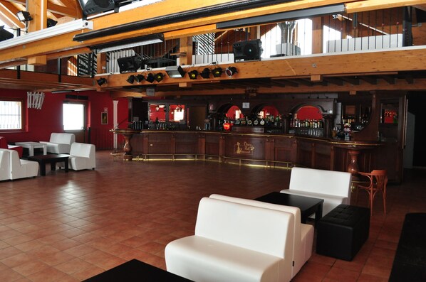 A spacious bar area with a high ceiling and wooden beams, featuring a bar counter with various bottles and a sign that reads "Pico Bar." - Grand Hotel Miramonti (Vermiglio)