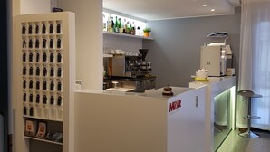 A modern kitchen with a built-in coffee machine, a minibar, and a display of keychains. - Hotel Mizar (Rimini)