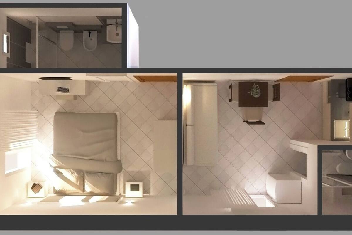A modern hotel room with a bed, bedside table, and a small bedside lamp.