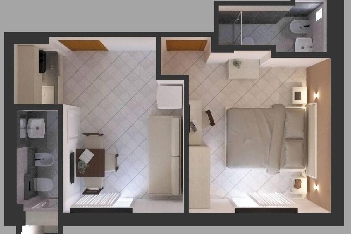 A modern hotel room with a bed, bedside table, lamp, and a bathroom with a toilet and sink.