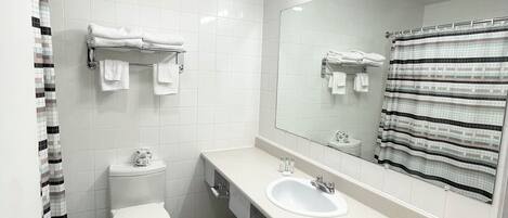 Un baño moderno con inodoro, lavamanos y espejo.