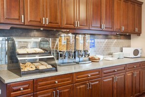 A breakfast bar with a coffee machine, a bread display, and a microwave. - Thriftlodge by Wyndham Moncton (Moncton)
