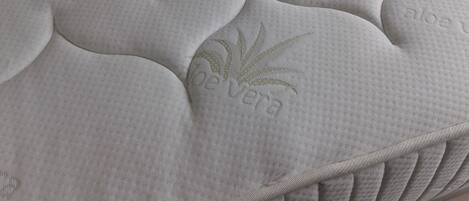Un matelas doté d’une surface texturée et ornée d’un motif en forme de feuilles en relief.