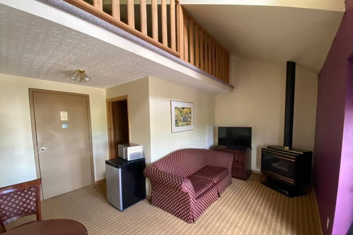 Une chambre d’hôtel équipée d’un lit, d’une télévision, d’un petit bureau et d’une cheminée.