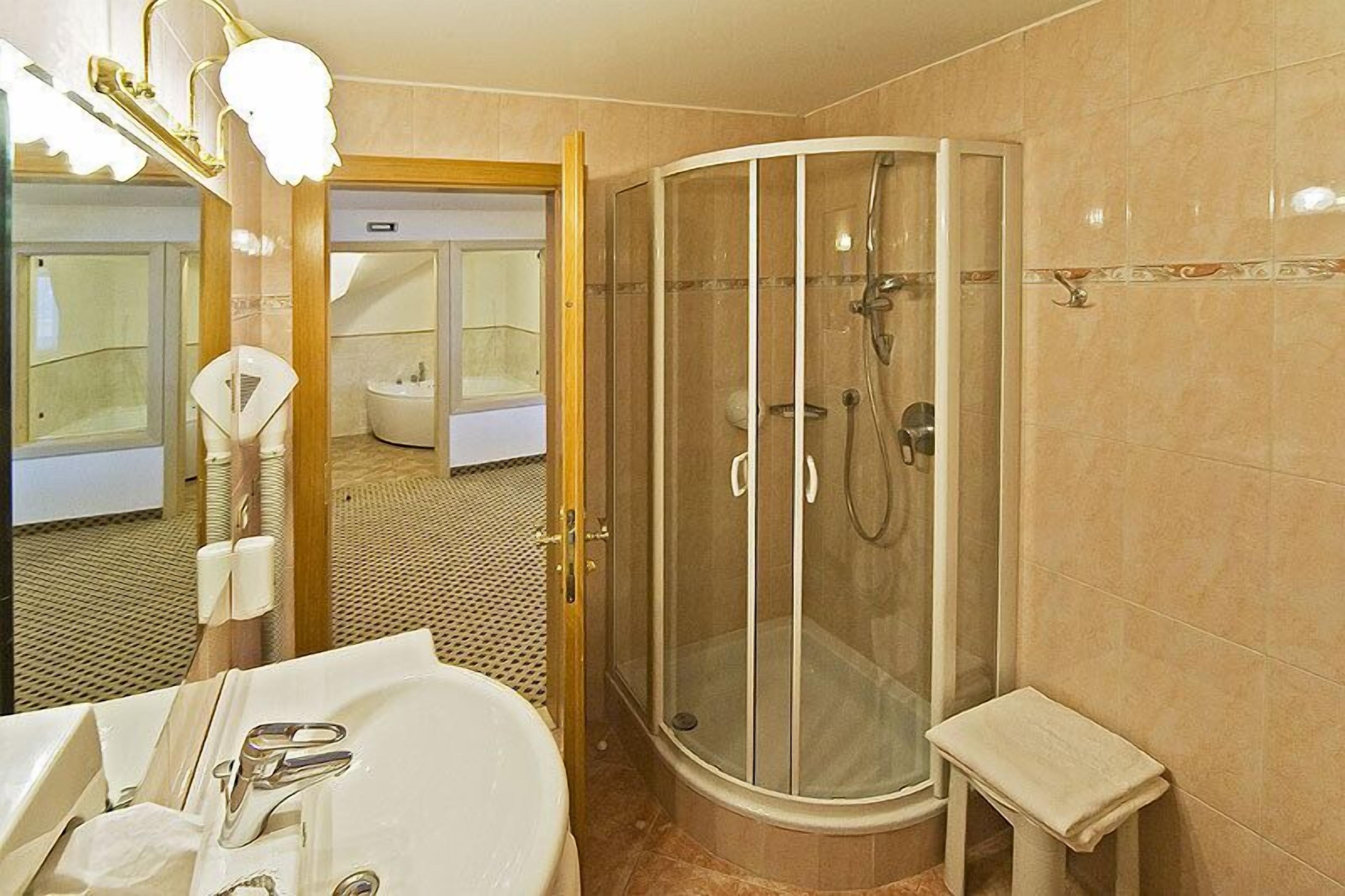 A modern bathroom with a glass-enclosed shower, a sink, and a toilet.