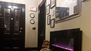 Una sala de estar con chimenea, televisor y comedor con mobiliario estampado.
