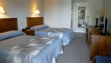 A hotel room with two beds, a desk, a chair, and a TV.