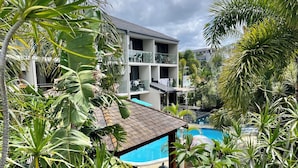 Ein mehrstöckiges Gebäude mit Pool, umgeben von tropischer Vegetation.