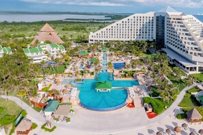 A resort with multiple swimming pools, a large hotel building, and a pyramid-shaped structure. - Iberostar Selection Cancún - All Inclusive (Cancun)