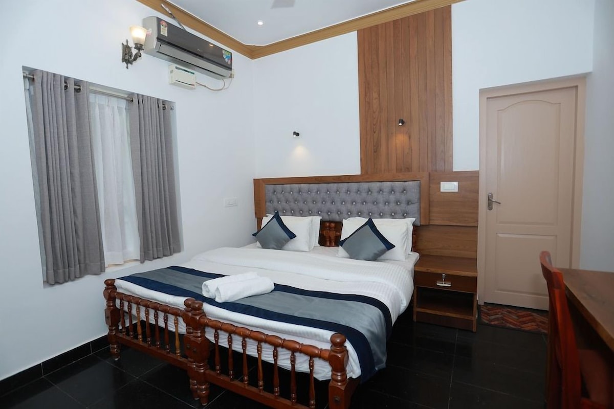 A bedroom with a wooden bed, grey curtains, a wooden headboard, and a white door.