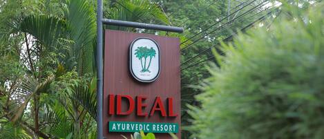 A sign for 'Ideal Ayurvedic Resort' with a logo of palm trees and the text 'Since 1997'.