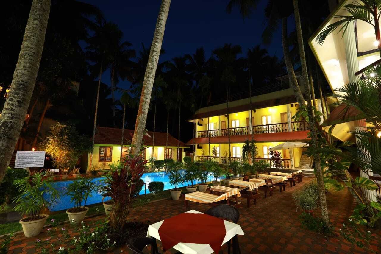 A two-story building with a pool and outdoor seating area.
