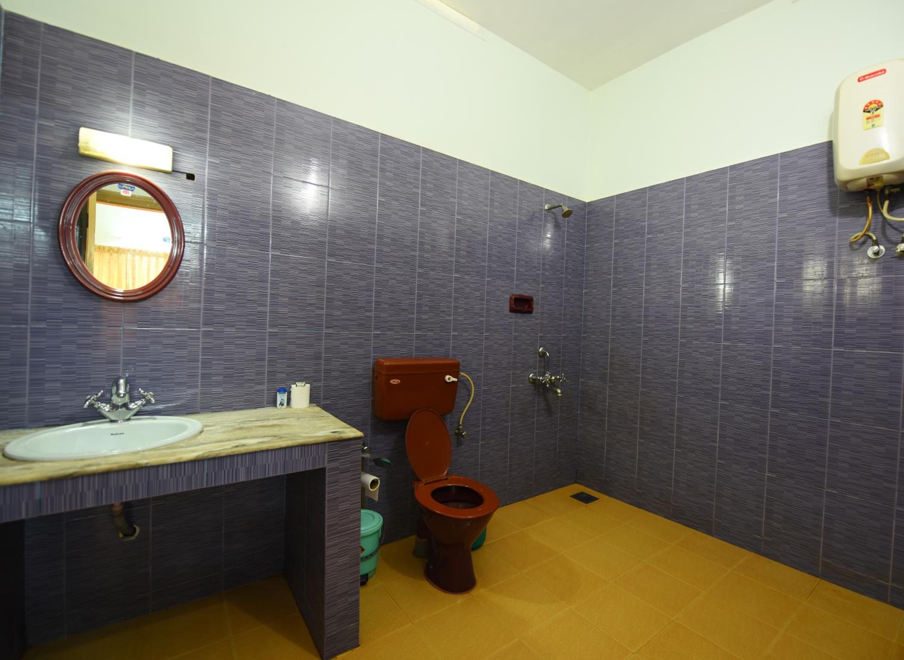 A bathroom with a sink, mirror, toilet, and shower.