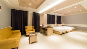 A modern hotel room with a yellow sofa, a desk with a computer, a bed, and a large mirror. - Reborn Suwon Silkroad Hotel (Suwon)
