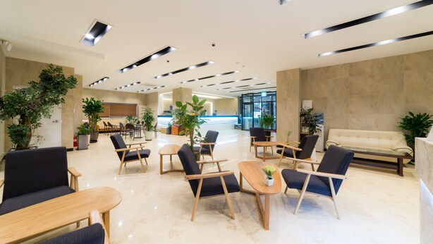 A spacious lobby with modern furniture, including sofas and chairs, and a reception area with a couch. - Reborn Suwon Silkroad Hotel (Suwon)