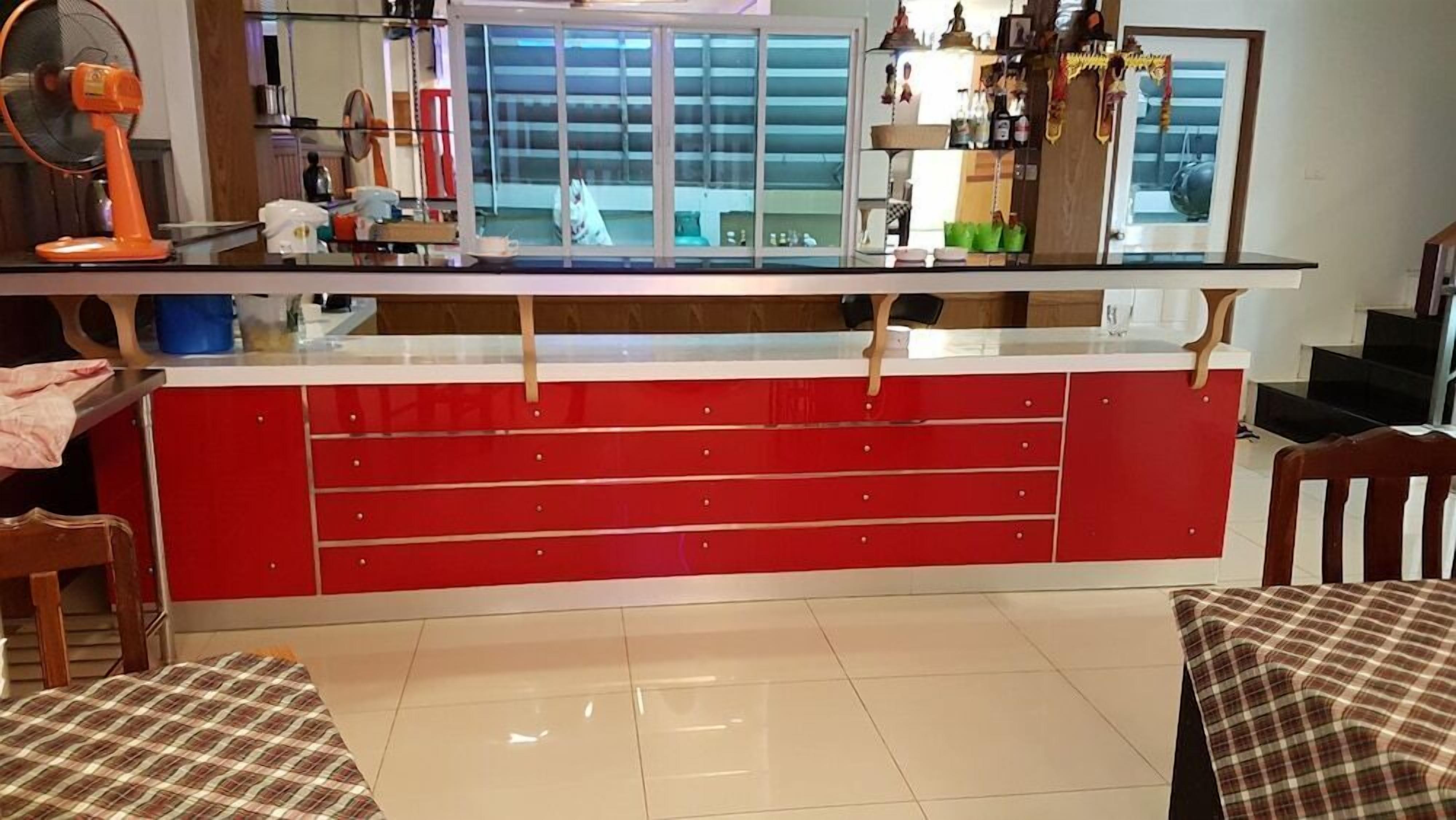 Una cocina con encimera roja, una ventana y vistas al exterior.