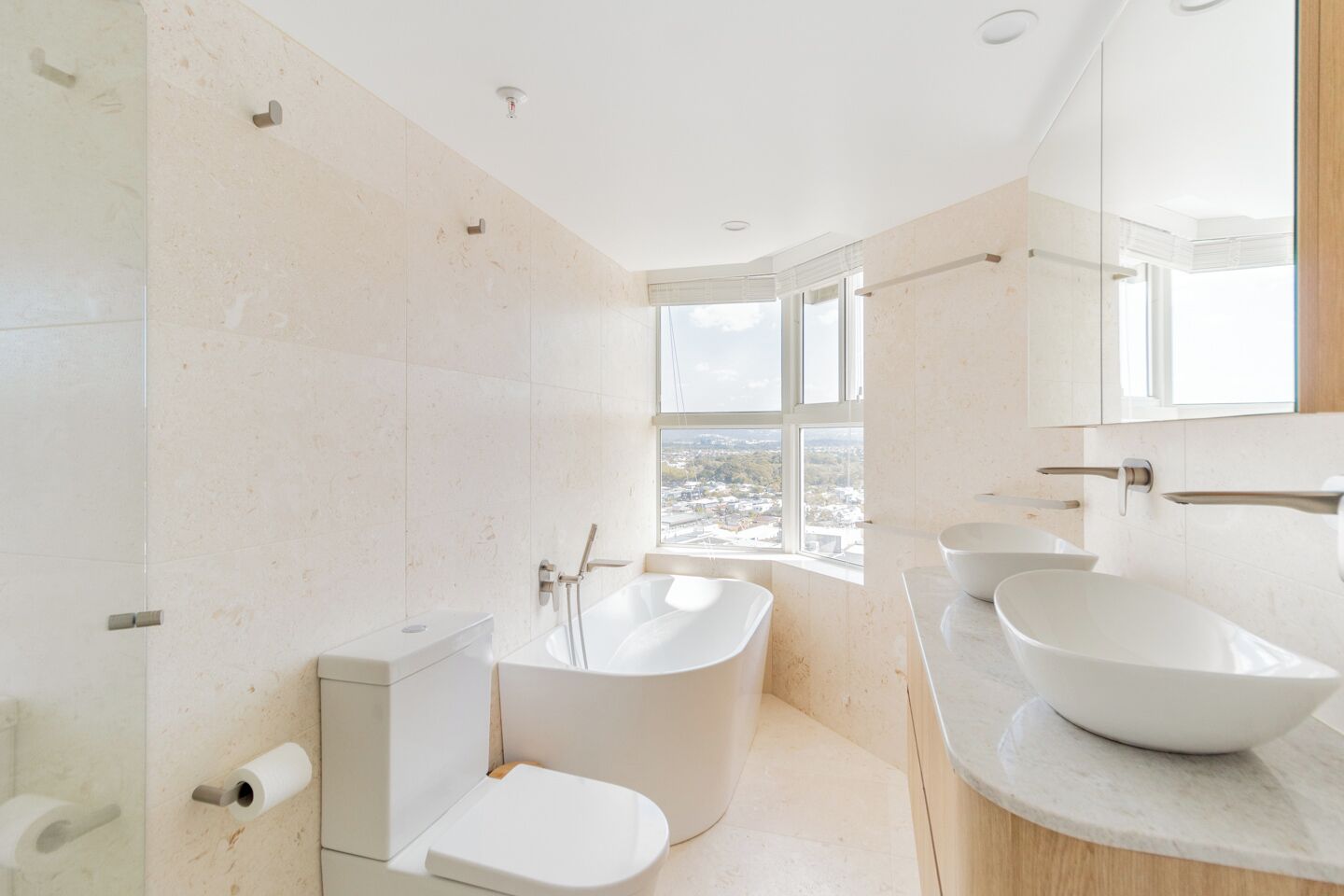 Un bany modern amb una banyera independent, un vàter i un lavabo gran.