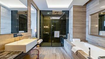 A modern bathroom with a large bathtub, a separate shower area, and a glass-enclosed walk-in shower.