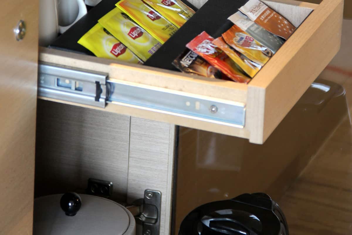 Eine Küchenschublade mit verschiedenen Lebensmitteln und einer Kaffeemaschine.
