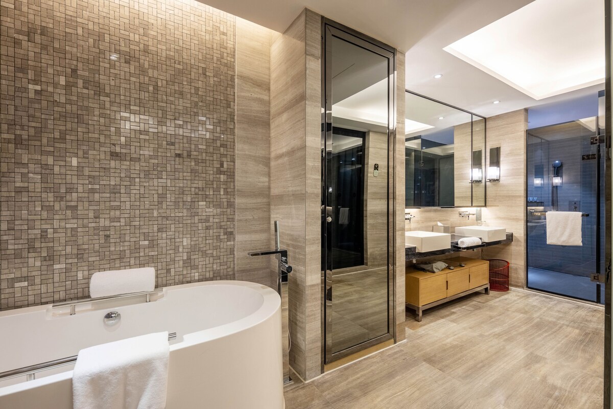 A modern bathroom with a freestanding bathtub, a glass shower enclosure, and a vanity with a mirror.
