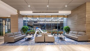 Eine moderne Lobby mit zwei Sofas, einem Couchtisch und Zimmerpflanzen.