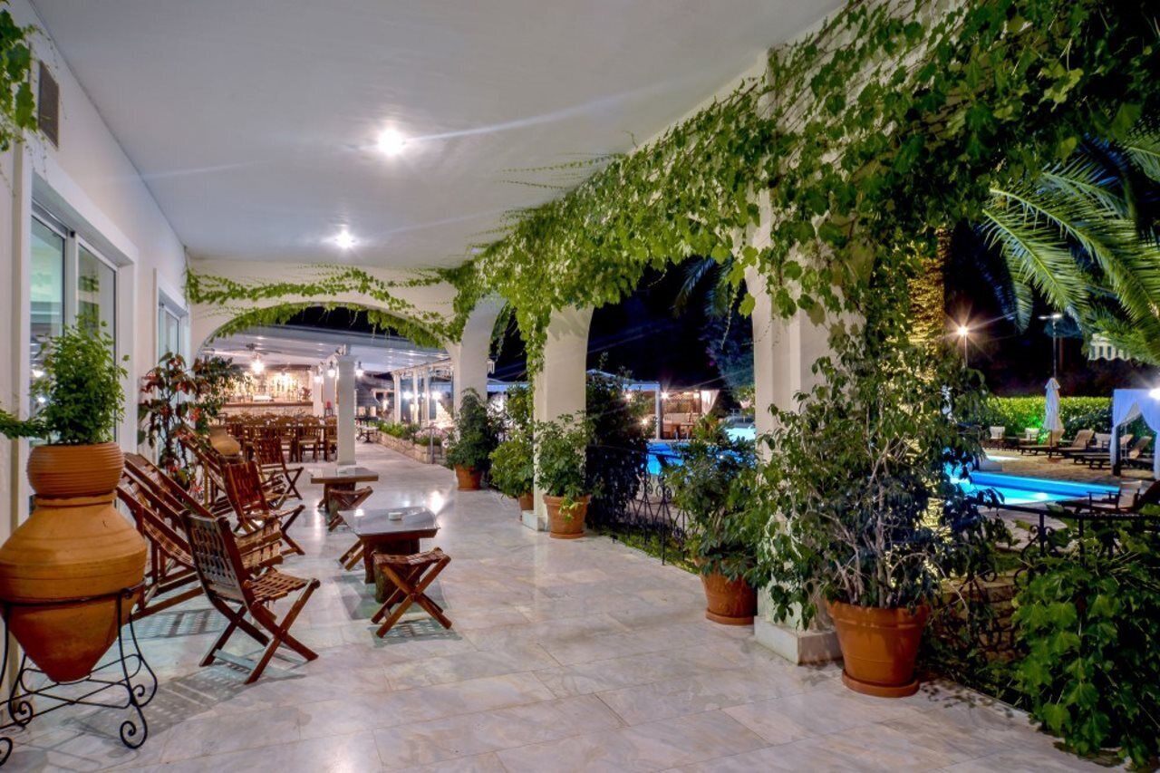 An indoor patio area with seating, a pool, and lush greenery.