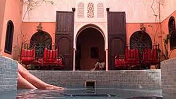 Una piscina al aire libre, sombrillas, tumbonas