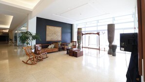 A spacious lobby with a seating area, large windows, and a modern ceiling design. - The Oriental Legazpi (Legazpi)