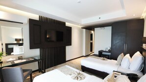 A modern hotel room with a large bed, a desk, a TV mounted on the wall, and a wardrobe. - The Oriental Legazpi (Legazpi)