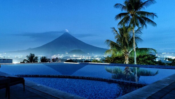 A pool with a view of a mountain at dusk. - The Oriental Legazpi (Legazpi)