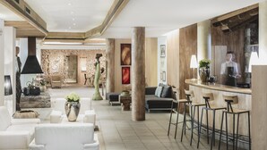 A spacious lobby with a bar area, seating arrangements, and a reception desk. - Hotel Bad Schoergau (Sarentino)
