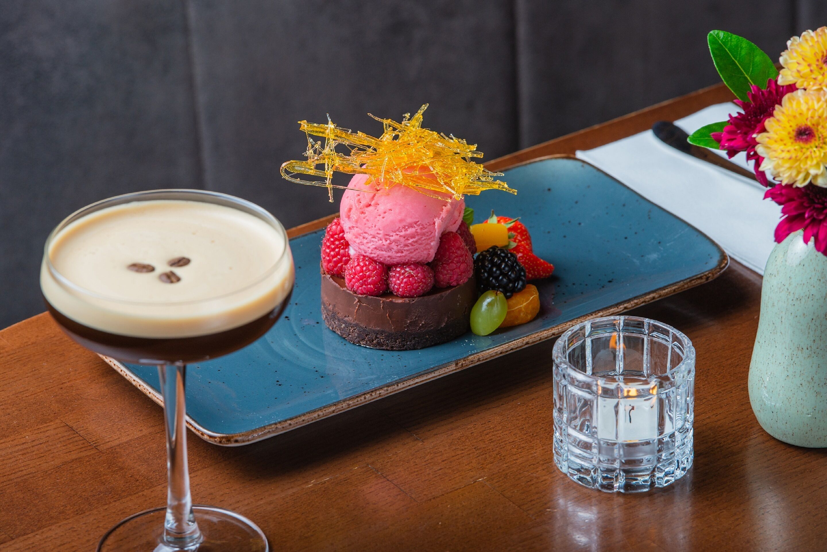 A dessert on a blue plate with a glass of a creamy beverage beside it.