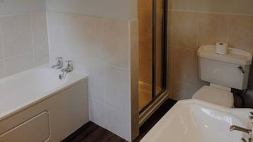 A bathroom with a bathtub, toilet, and shower.