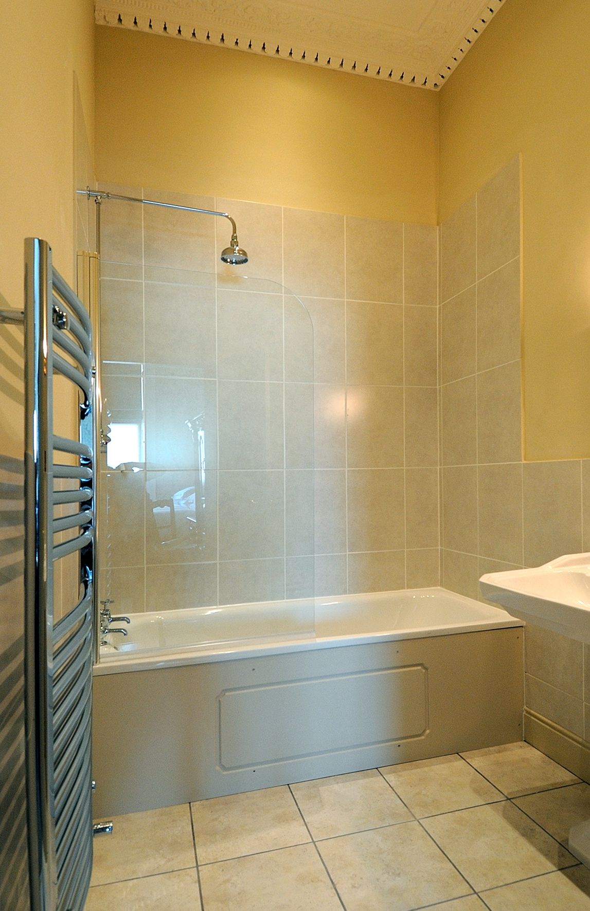A bathroom with a shower enclosure, a bathtub, and a sink.
