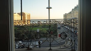 A balcony with wrought iron railings overlooking a city street with buildings and a tower. - Regency Hotel (Brighton)