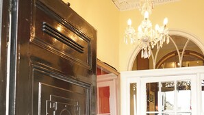 A black door with the number 28, a white door with glass panels, and a chandelier above. - Regency Hotel (Brighton)