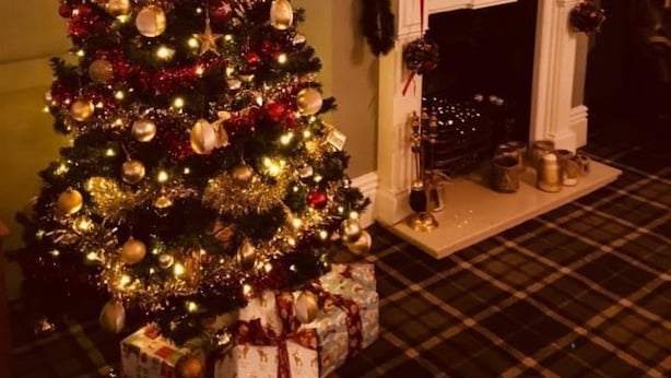A Christmas tree with ornaments and lights, a fireplace, and a mirror with a gold frame. - The New Inn (Beverley)