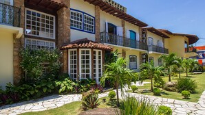 A two-story building with a balcony, stone pathway, and tropical plants. - Pousada Eclipse (Paraty)