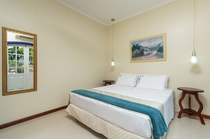 Un dormitorio con una cama, una mesita de noche, un espejo y un cuadro en la pared.