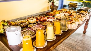 A buffet table with various food items and beverages. - Pousada Eclipse (Paraty)