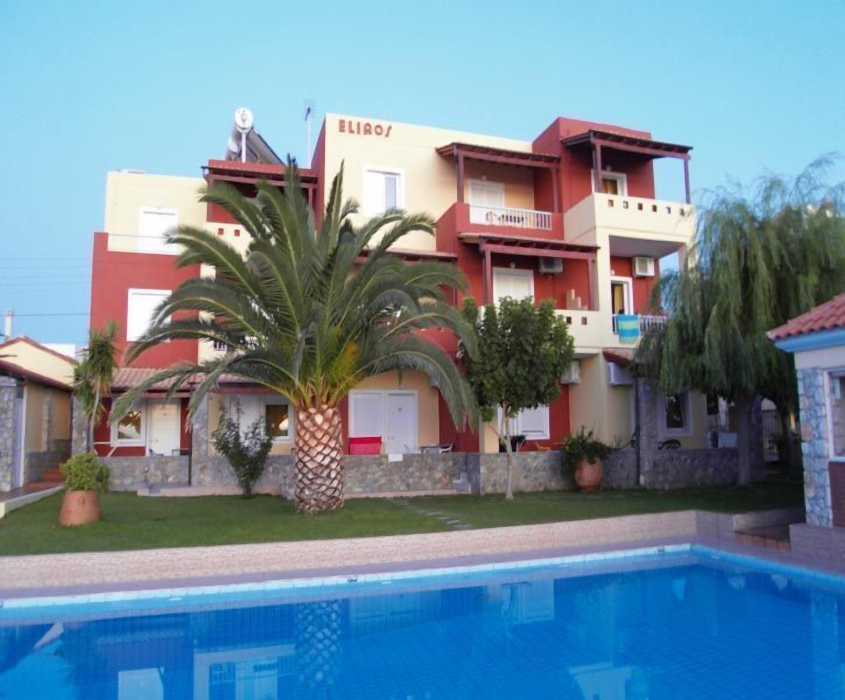 A multi-story building with a swimming pool in front.