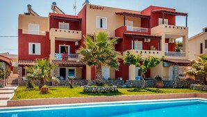 A multi-story building with balconies, a swimming pool, and a well-maintained lawn. - Eliros Studios (Chania)