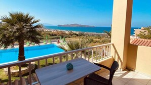 A balcony with a view of a swimming pool and the sea. - Eliros Studios (Chania)